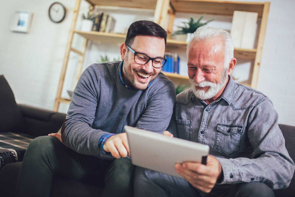 Father and son sharing a moment with a tablet — discussing future plans together