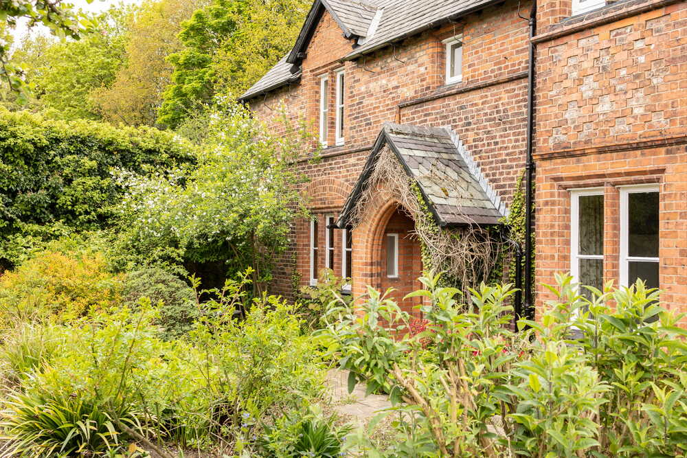 Traditional English brick cottage with garden — representing the family home and legacy